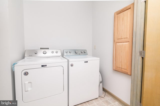 laundry room featuring cabinets and washing machine and clothes dryer