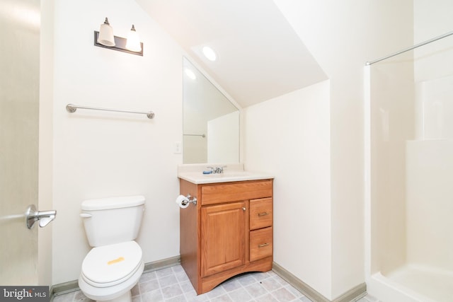 bathroom featuring vanity, a shower, vaulted ceiling, and toilet