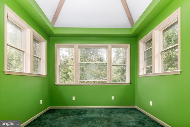 spare room with vaulted ceiling with beams and dark colored carpet