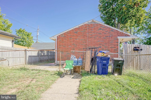 view of home's exterior with brick siding, fence, and a yard