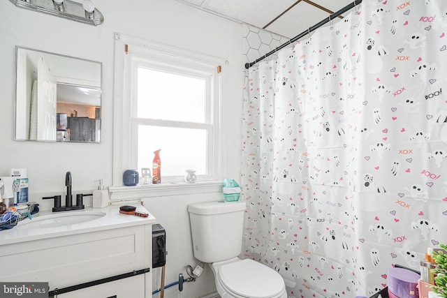 bathroom with a paneled ceiling, toilet, a shower with shower curtain, and vanity
