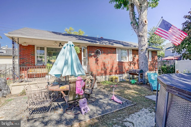 back of property featuring brick siding and fence