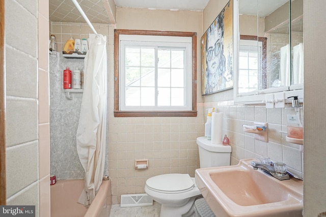 full bathroom with shower / tub combo with curtain, tile walls, sink, and toilet