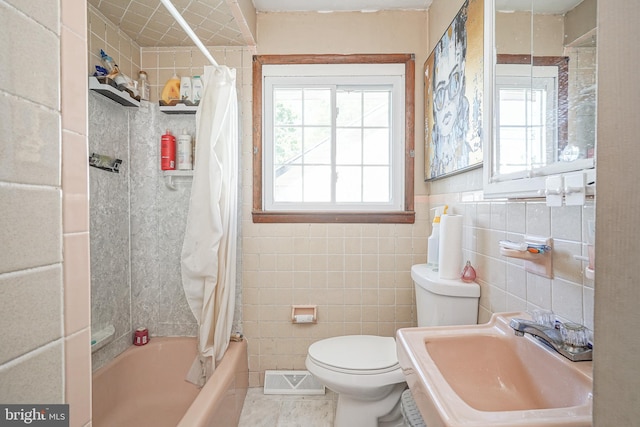 bathroom with shower / bath combo, visible vents, a sink, tile walls, and toilet