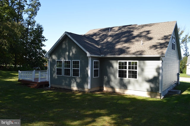 rear view of house with a deck and a lawn