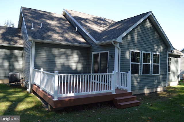 rear view of property featuring a yard, a deck, and central air condition unit