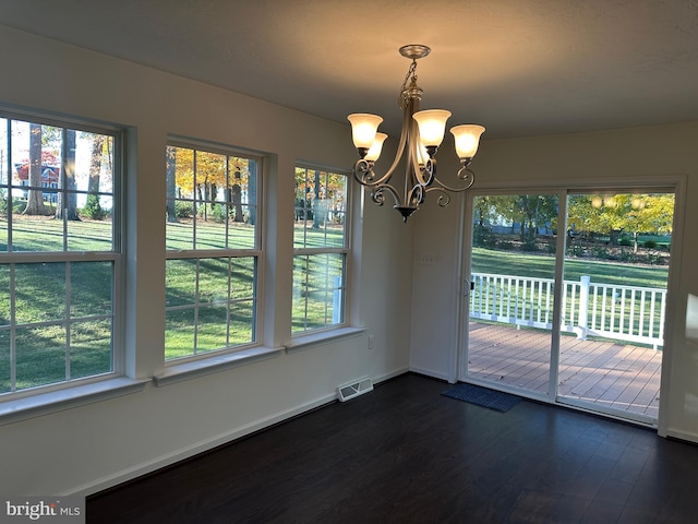 unfurnished dining area featuring dark hardwood / wood-style floors and a chandelier