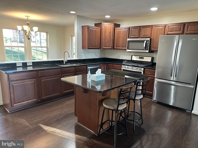 kitchen featuring dark wood-type flooring, a notable chandelier, stainless steel appliances, and sink