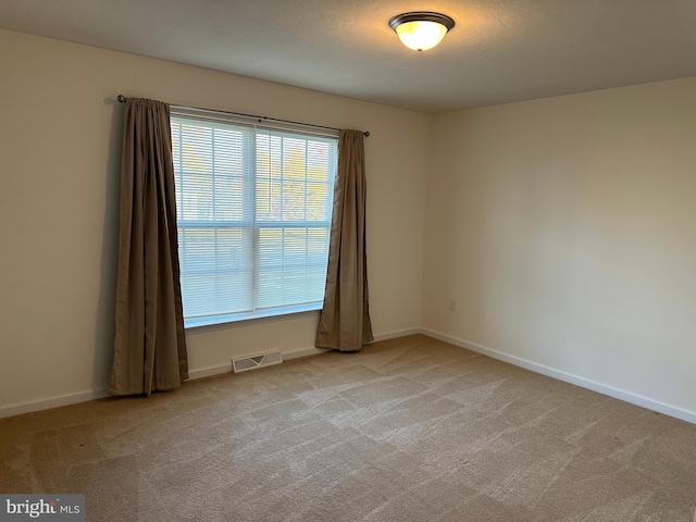 carpeted spare room featuring a textured ceiling