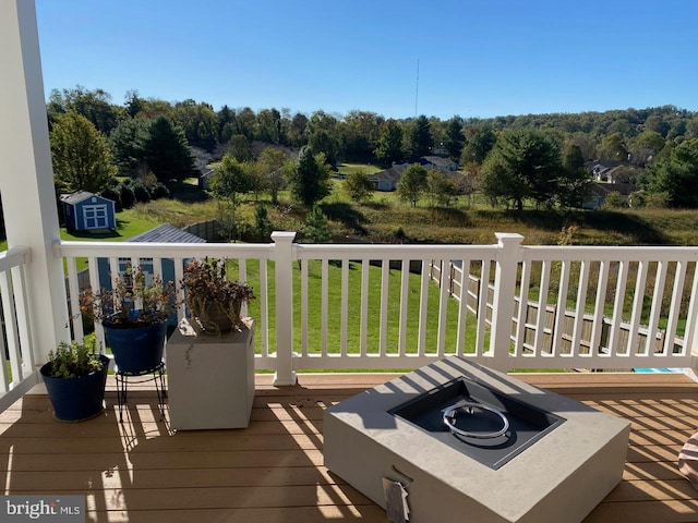 deck featuring a lawn and a storage shed