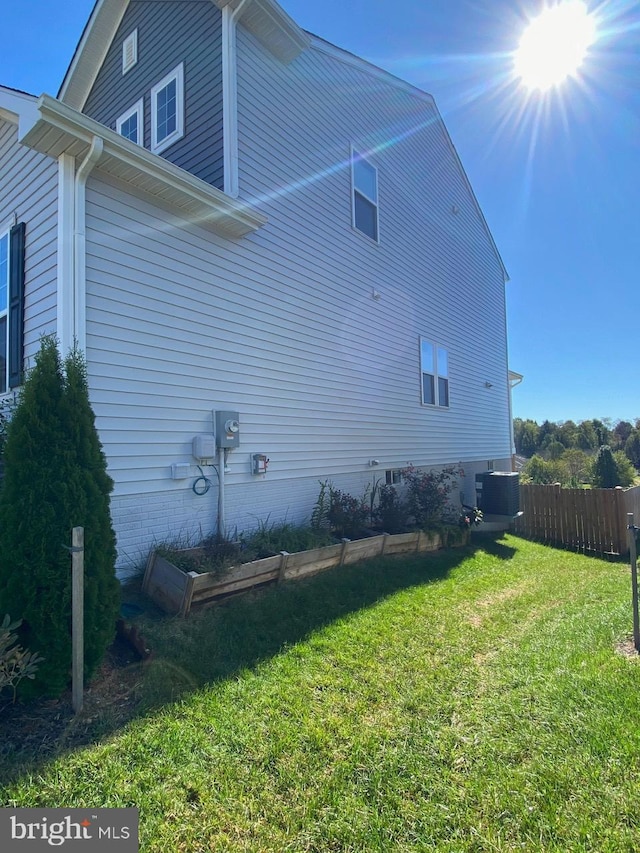 view of home's exterior featuring central AC unit and a lawn