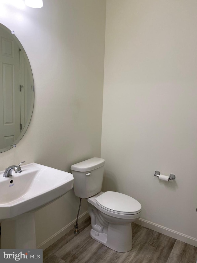 bathroom with hardwood / wood-style flooring and toilet