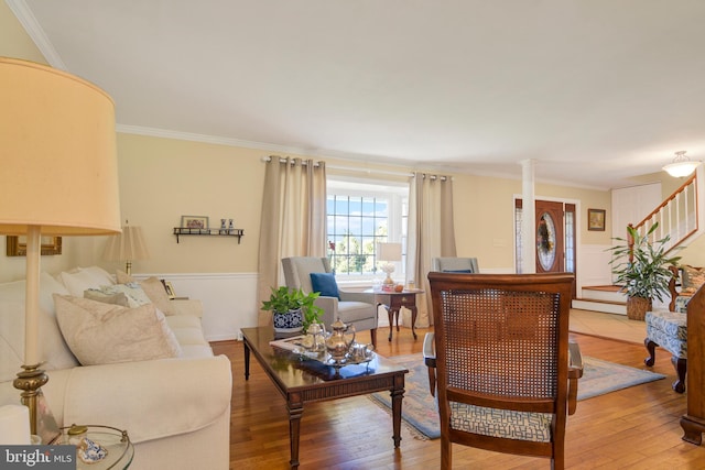 living room with hardwood / wood-style floors, ornamental molding, and ornate columns