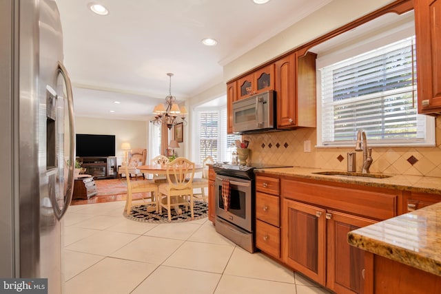 kitchen with a wealth of natural light, crown molding, sink, and appliances with stainless steel finishes