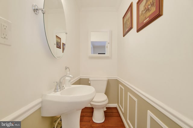 bathroom with crown molding, wood-type flooring, and toilet