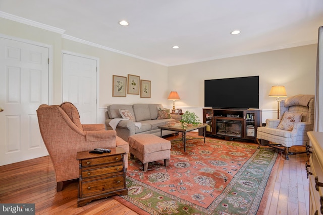 living room with hardwood / wood-style flooring and crown molding