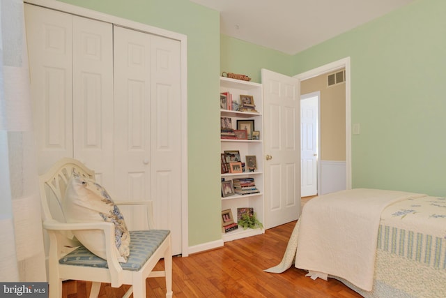 bedroom with wood-type flooring and a closet