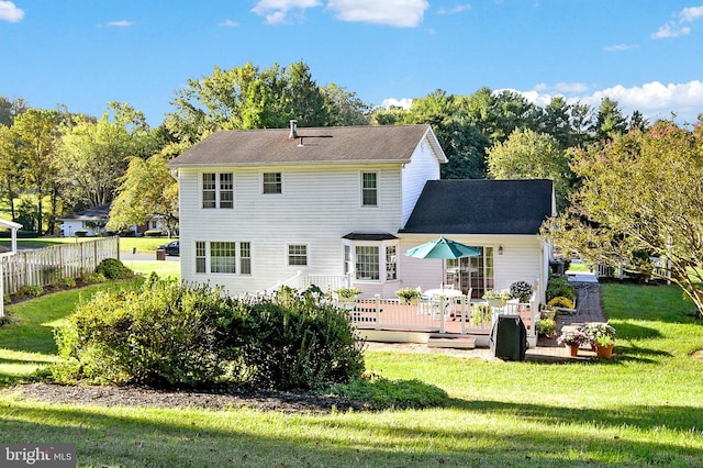 back of property with a lawn and a wooden deck