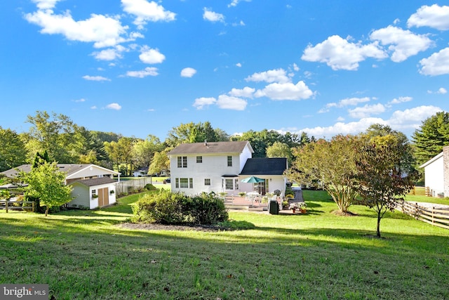 back of house featuring a lawn and a wooden deck