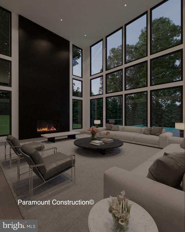 living room featuring expansive windows, a fireplace, and a towering ceiling