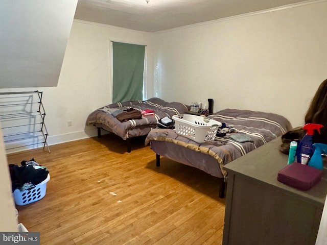 bedroom with wood-type flooring and crown molding