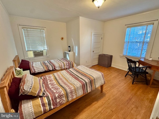 bedroom with ornamental molding, cooling unit, and light hardwood / wood-style flooring