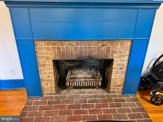 details with wood-type flooring and a brick fireplace