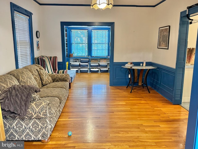 living room with ornamental molding and light hardwood / wood-style floors