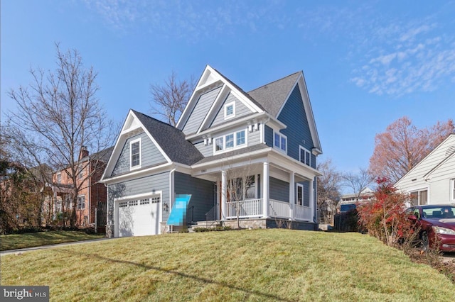 view of front of house with a garage, covered porch, and a front yard