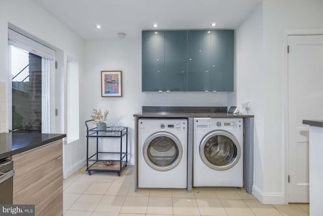 clothes washing area featuring light tile patterned floors and washing machine and clothes dryer