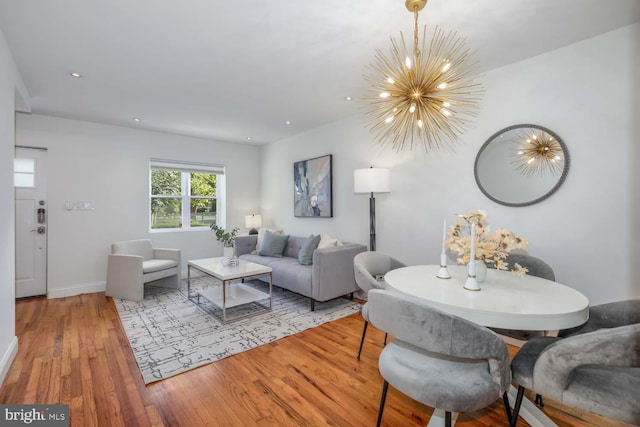 living room with light hardwood / wood-style flooring and a notable chandelier