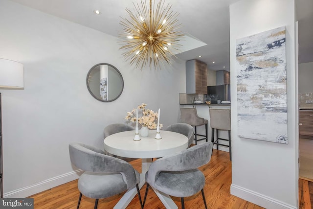 dining space with a chandelier and light wood-type flooring