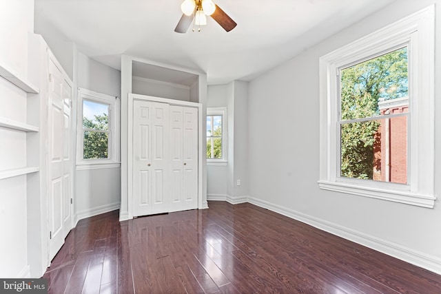 unfurnished bedroom with dark hardwood / wood-style floors, multiple windows, and ceiling fan