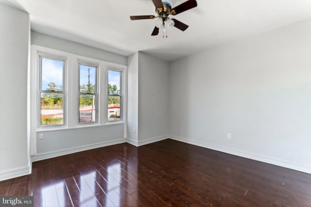 unfurnished room featuring ceiling fan and dark wood-type flooring