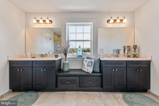 bathroom with a sink, baseboards, and two vanities