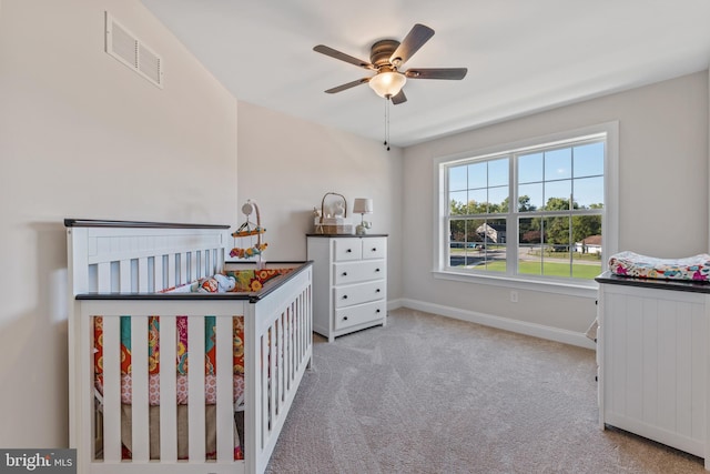 unfurnished bedroom with baseboards, visible vents, ceiling fan, and light colored carpet