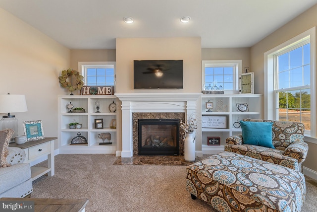 living area featuring carpet floors, a premium fireplace, recessed lighting, and baseboards