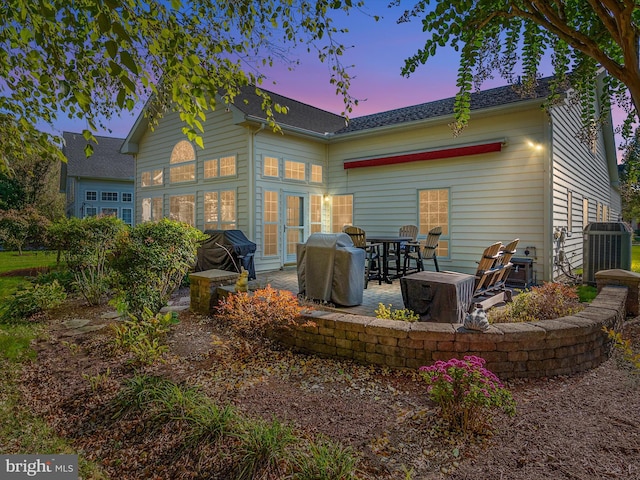 back house at dusk featuring french doors and a patio area