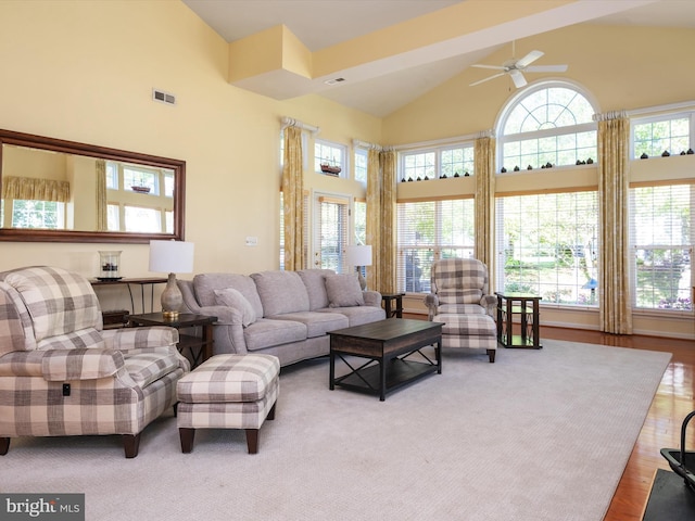 living room featuring wood-type flooring, high vaulted ceiling, and a healthy amount of sunlight