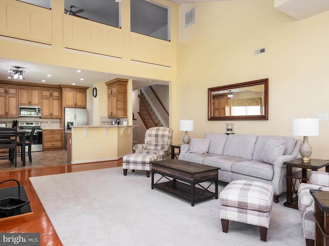 living room with light hardwood / wood-style floors and a high ceiling