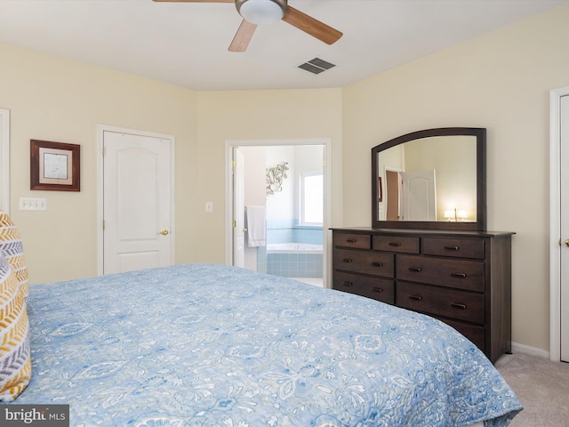 bedroom featuring light colored carpet, ensuite bath, and ceiling fan