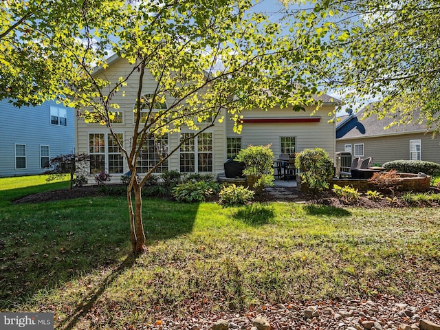 rear view of property with a yard and a patio area