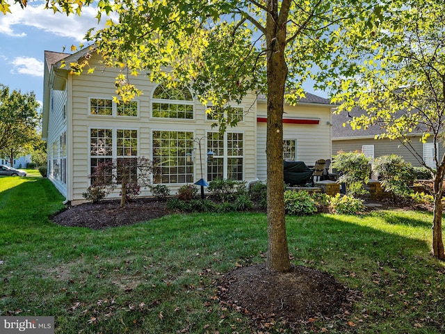 rear view of house featuring a lawn