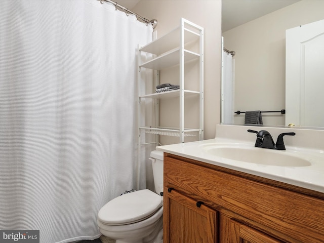 bathroom with walk in shower, vanity, and toilet