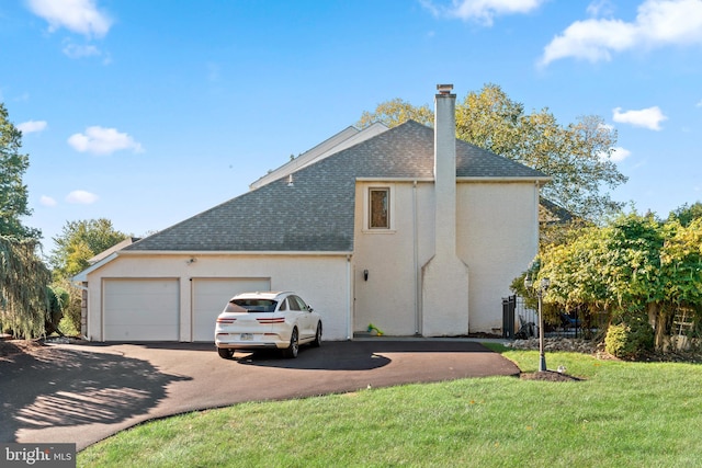 view of side of property with a garage and a lawn