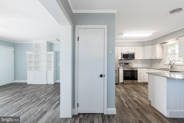 kitchen with crown molding, dark wood-type flooring, white cabinetry, and stainless steel appliances