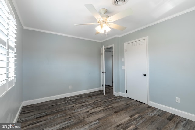 empty room with crown molding, ceiling fan, and dark hardwood / wood-style flooring