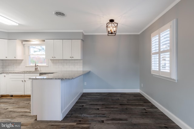 kitchen with a wealth of natural light, dark wood-type flooring, and white cabinets