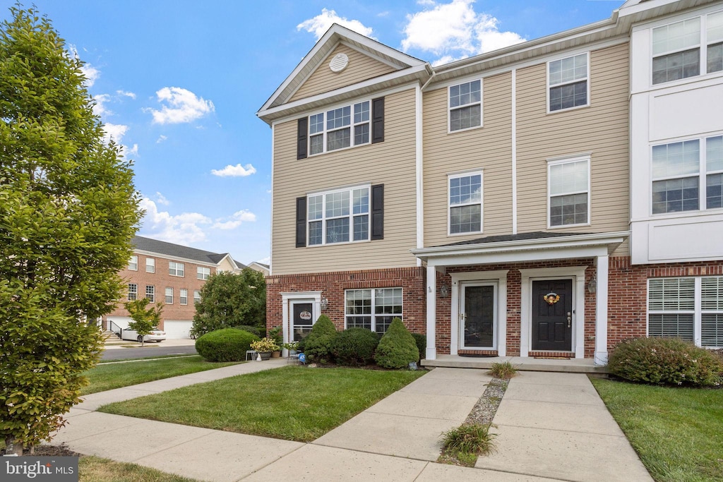 townhome / multi-family property featuring a front lawn