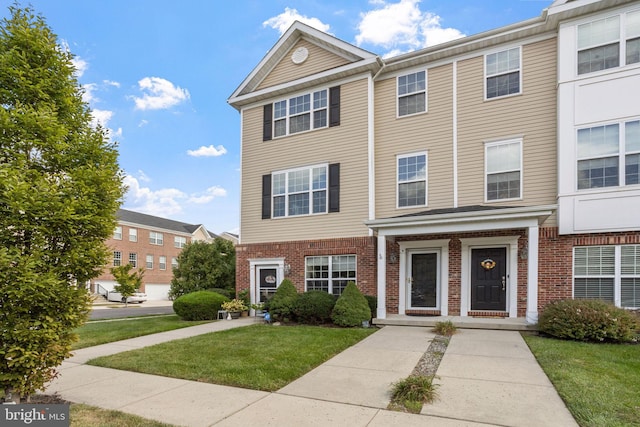 townhome / multi-family property featuring a front lawn